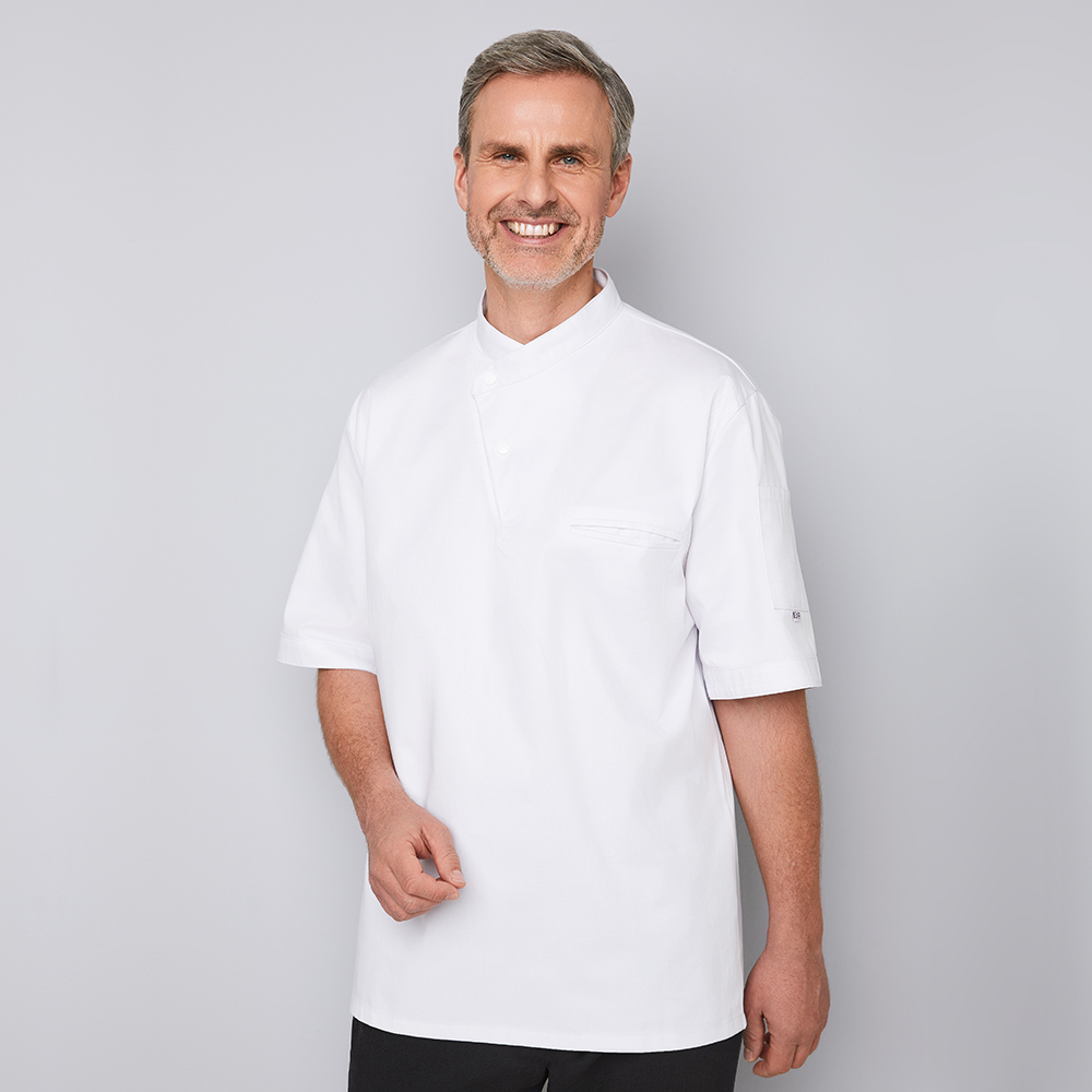 Halbarm. Mit zwei asymmetrischen Druckknöpfen. Trapezform. Innenliegende Brustleistentasche.